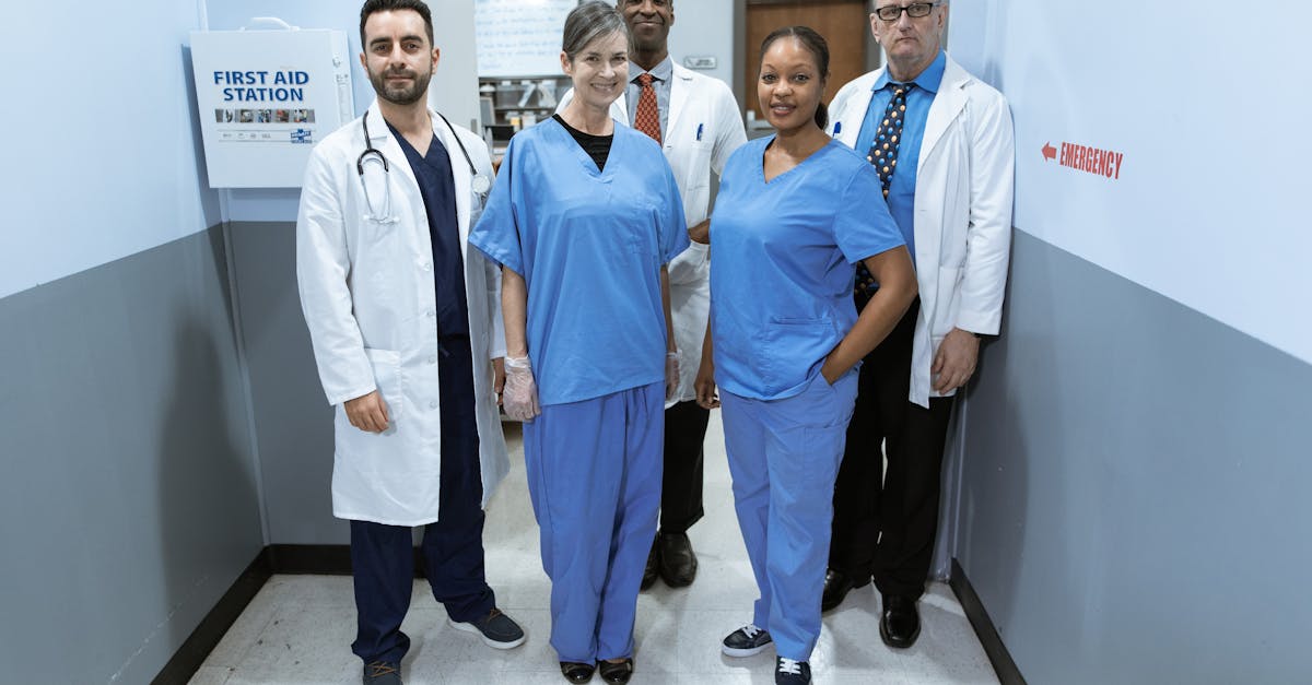 A diverse team of smiling healthcare professionals in a hospital hallway discussing a patient's case.